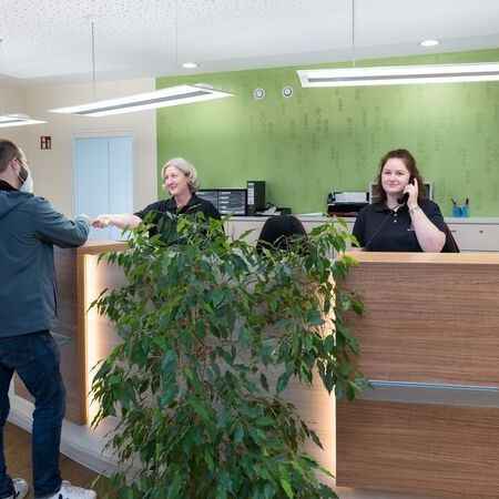 Rezeption der Urologie-Praxis Lüneburg mit zwei Mitarbeitenden und einem Patienten