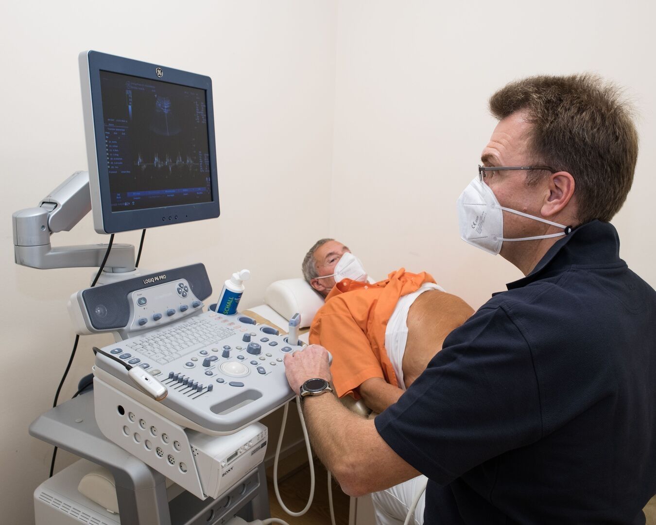 Mediziner führt bei einem Patienten eine Ultraschalluntersuchung durch